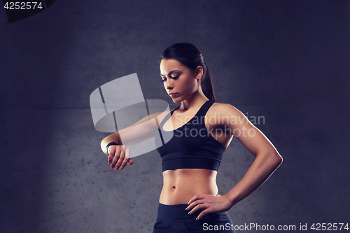 Image of young woman with heart-rate watch in gym