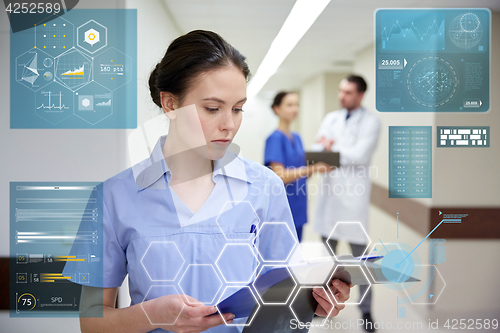 Image of female doctor or nurse with clipboard at hospital