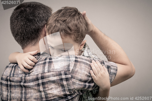 Image of sad son hugging his dad