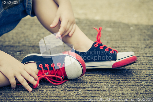 Image of youth sneakers on boy legs on road