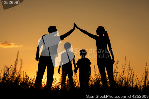 Image of Happy family standing in the park.