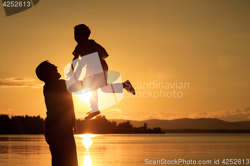 Image of father and son playing on the coast of lake