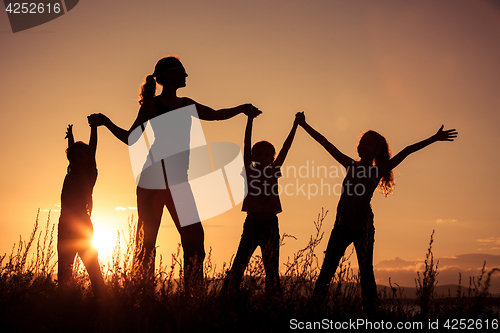 Image of Happy family standing in the park.