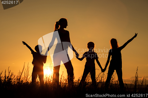 Image of Happy family standing in the park.