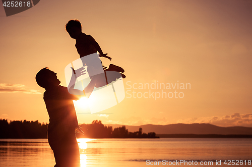 Image of father and son playing on the coast of lake