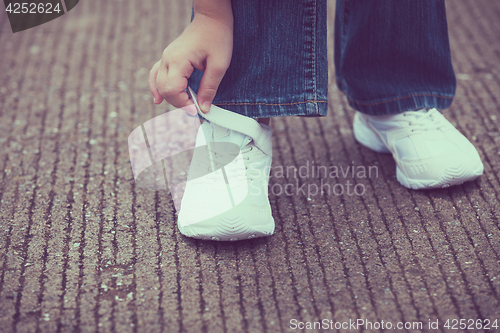 Image of youth sneakers on girl legs on road