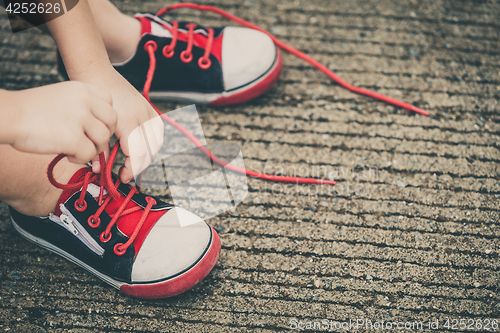 Image of youth sneakers on boy legs on road