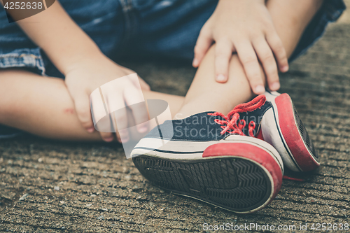 Image of youth sneakers on boy legs on road 