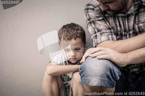 Image of sad son hugging his dad