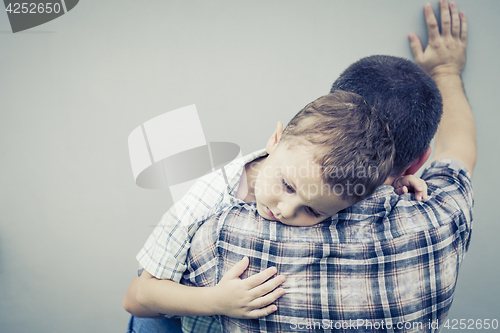 Image of sad son hugging his dad