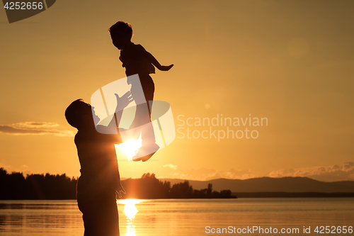 Image of father and son playing on the coast of lake