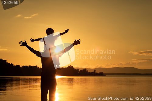 Image of father and son playing on the coast of lake