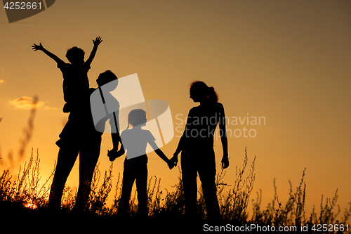 Image of Happy family standing in the park.