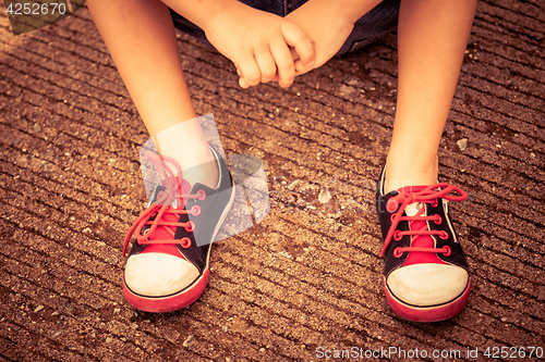 Image of youth sneakers on boy legs on road