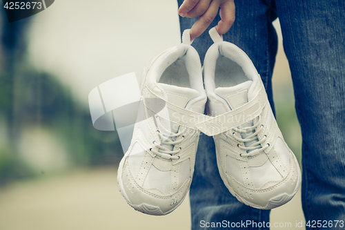 Image of youth sneakers on girl legs on road