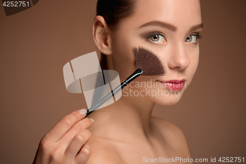 Image of Beauty Girl with Makeup Brush. Perfect Skin. Applying Makeup