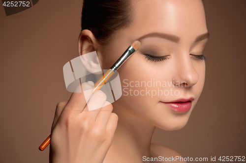 Image of Beauty Girl with Makeup Brush. Perfect Skin. Applying Makeup