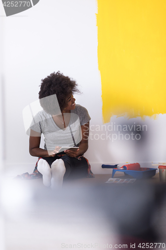 Image of back female painter sitting on floor