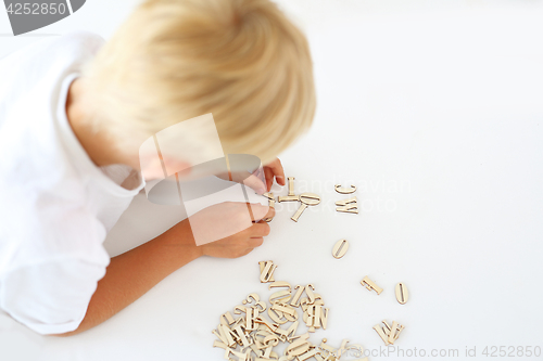 Image of Child on impact string of wooden letters