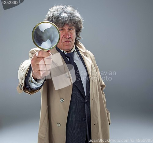 Image of The senior man as detective or boss of mafia on gray studio background