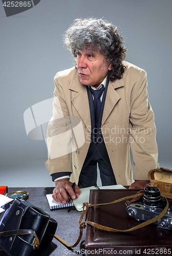 Image of The senior man as detective or boss of mafia on gray studio background