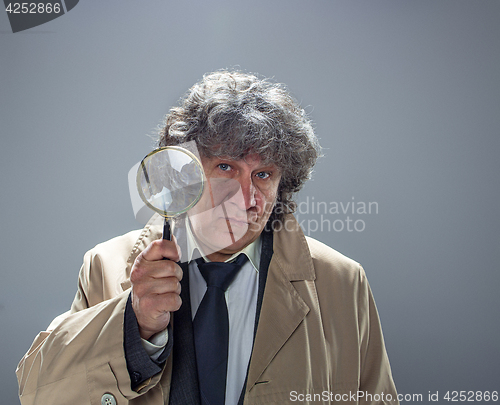 Image of The senior man as detective or boss of mafia on gray studio background