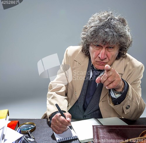 Image of The senior man as detective or boss of mafia on gray studio background