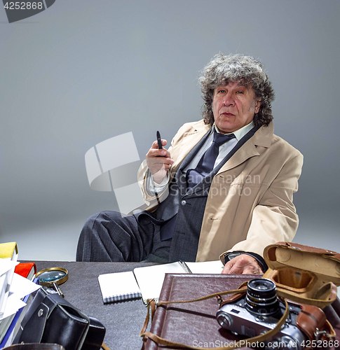 Image of The senior man as detective or boss of mafia on gray studio background