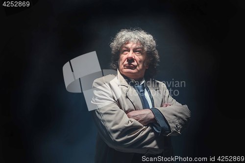 Image of The senior man as detective or boss of mafia on gray studio background