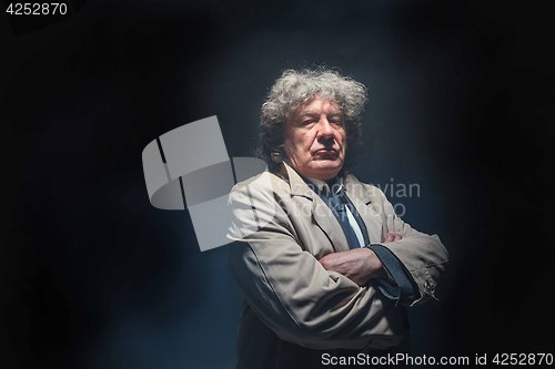 Image of The senior man as detective or boss of mafia on gray studio background