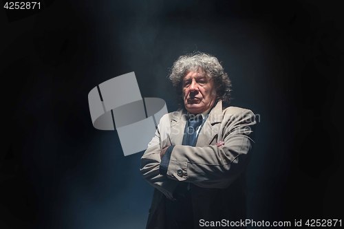 Image of The senior man as detective or boss of mafia on gray studio background