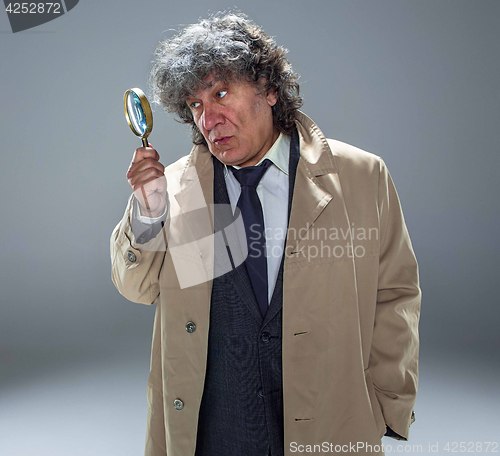 Image of The senior man as detective or boss of mafia on gray studio background