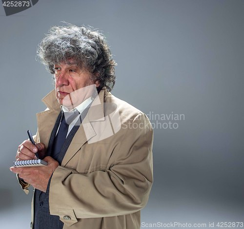 Image of The senior man as detective or boss of mafia on gray studio background