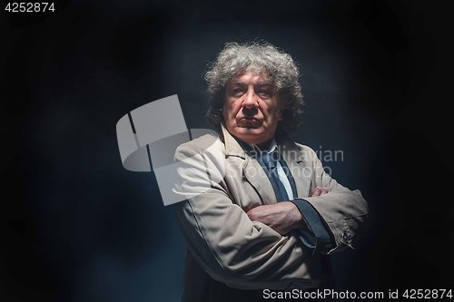 Image of The senior man as detective or boss of mafia on gray studio background