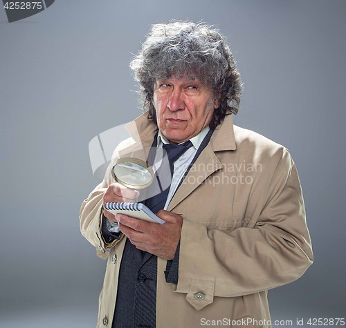 Image of The senior man as detective or boss of mafia on gray studio background