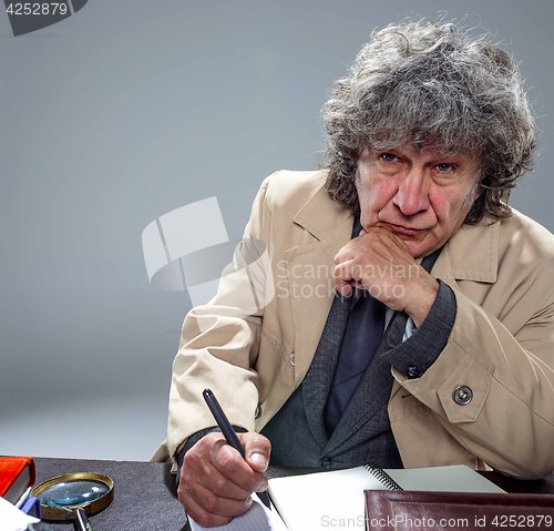 Image of The senior man as detective or boss of mafia on gray studio background