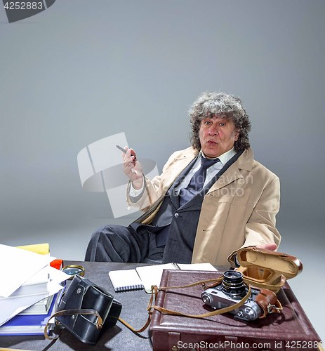 Image of The senior man as detective or boss of mafia on gray studio background