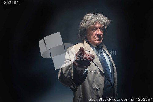 Image of The senior man as detective or boss of mafia on gray studio background