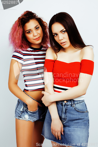 Image of lifestyle people concept: two pretty stylish modern hipster teen girl having fun together, diverse nation mixed races, happy smiling making selfie closeup