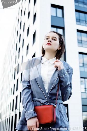 Image of young pretty brunette business woman posing against modern building, lifestyle people concept