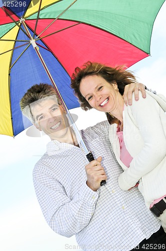 Image of Happy mature couple with umbrella