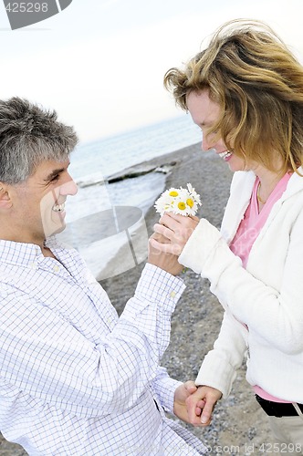 Image of Mature romantic couple with flowers