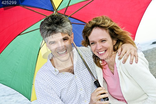 Image of Happy mature couple with umbrella