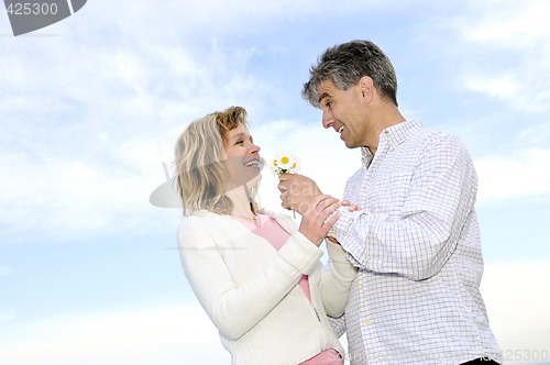 Image of Mature romantic couple with flowers