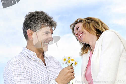 Image of Mature romantic couple with flowers