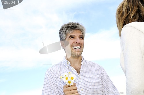 Image of Mature romantic couple with flowers