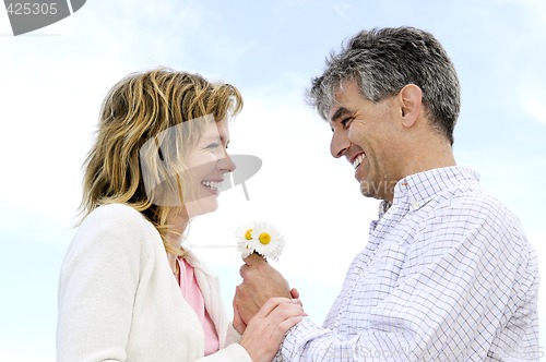 Image of Mature romantic couple with flowers