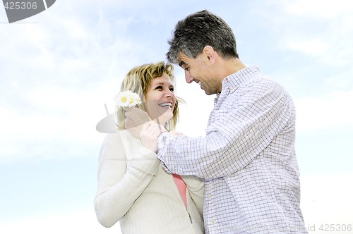 Image of Mature romantic couple with flowers