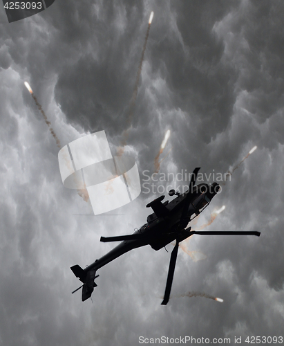 Image of Silhouette of an attack helicopter firing flares