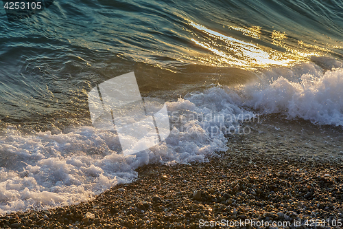 Image of Surf wave on the beach in the evening.